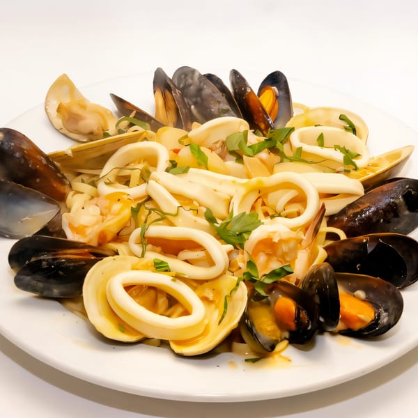 A plate of seafood pasta with mussels, clams, and calamari, garnished with fresh parsley.